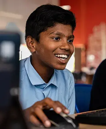 community outreach by embassy group - boy using computers